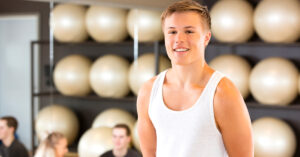 Good looking young man wearing a white singlet in a gym sex worker discrimination